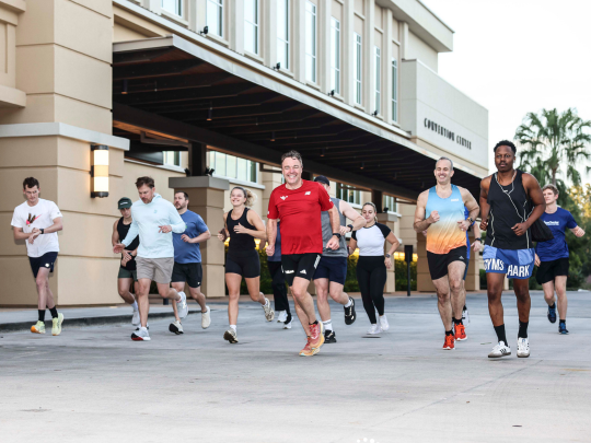 A group of Connected Claims USA attendees running together outside the convention centre during a morning 5K social event.