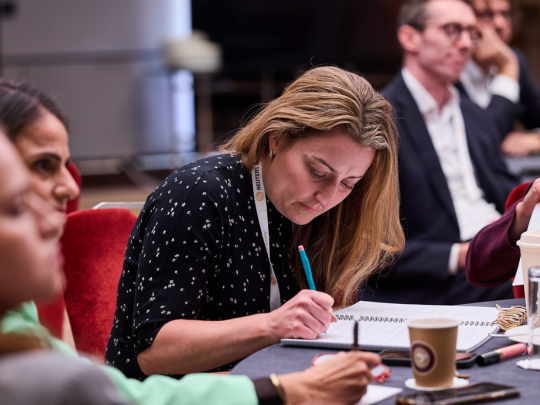 Energy Transition Europe attendee taking notes during a workshop discussion.