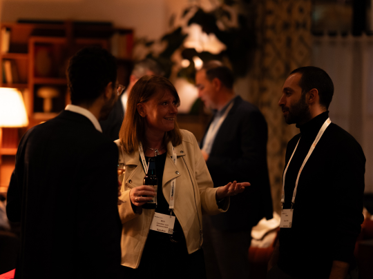 Supply chain professionals networking in a relaxed evening setting at Supply Chain Europe, with attendees engaged in conversation and wearing event lanyards.