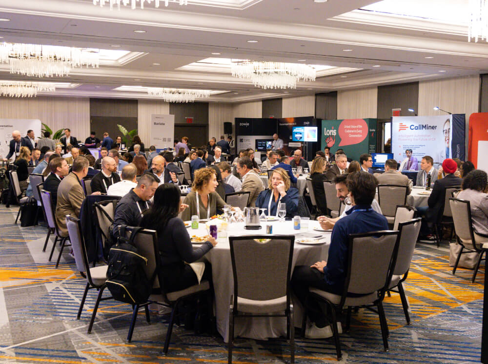 Attendees seated at round banquet tables dining and networking in a large ballroom during a lunch session at a Reuters Events conference.