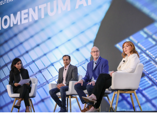 Four speakers participating in a Momentum AI panel discussion on stage.