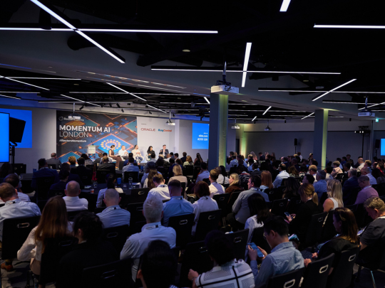 A large audience watches a panel discussion on stage at Momentum AI Austin.