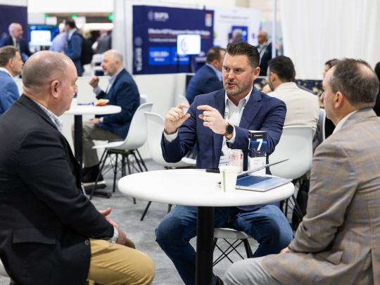 Three men networking around a table at Reuters Events Pharma USA 2026