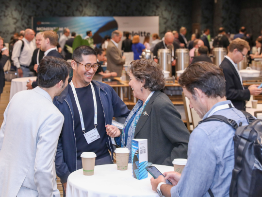 Momentum AI attendees networking around a cocktail table during a reception.