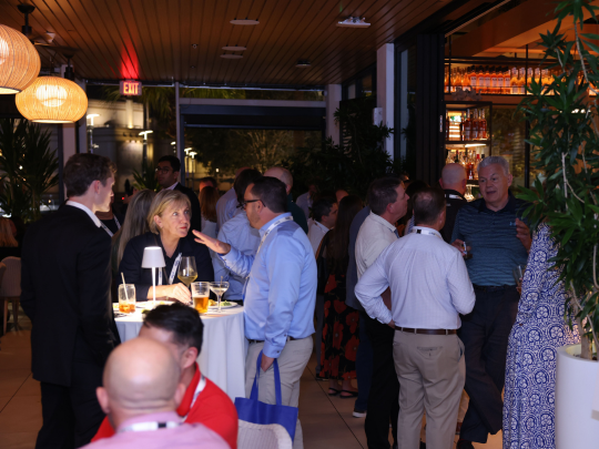 Connected Claims USA delegates mingling over drinks at an outdoor evening networking reception.