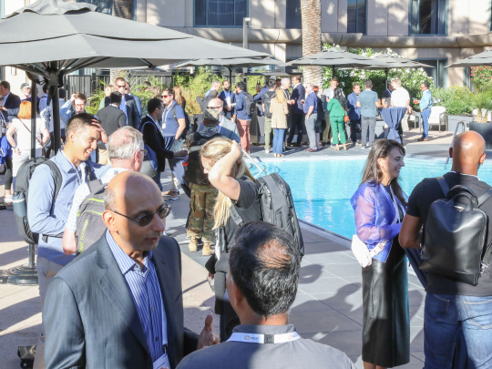 Momentum AI Austin attendees network beside the hotel pool during an outdoor drinks reception.