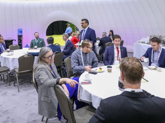 Attendees network over coffee and refreshments at round tables during Energy LIVE, with colleagues in conversation throughout a dome-shaped venue space.