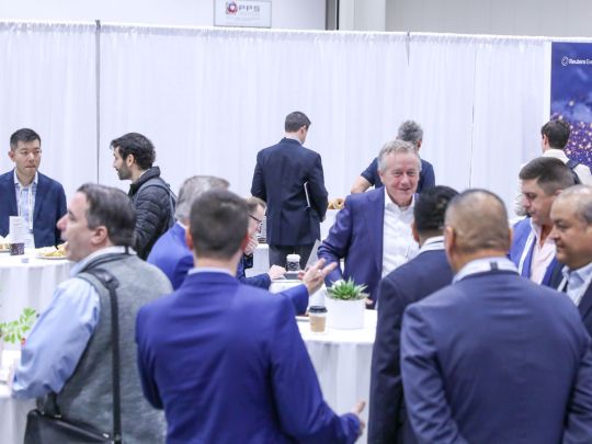 Attendees mingle and network near a round table during a bingo-style networking activity at Energy LIVE.