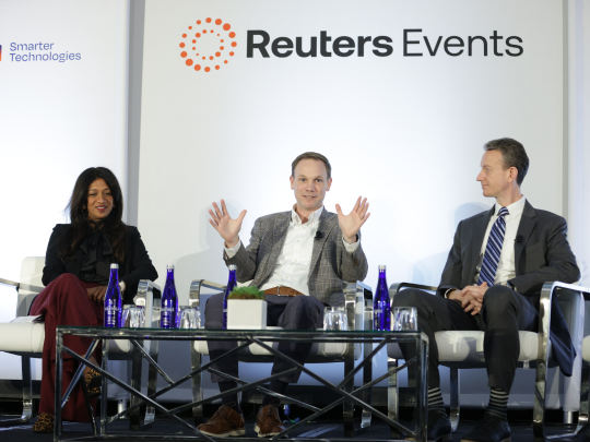 Three panelists speak onstage during a Reuters Events session at the Total Health conference.
