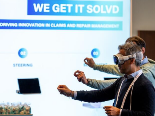 Insurance conference attendees trying a virtual reality demo about claims and repair management.
