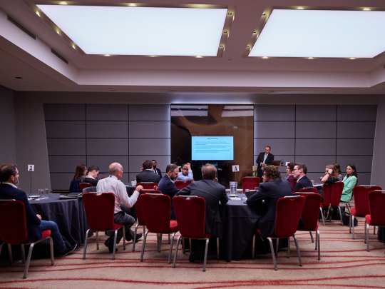 Conference speaker addressing attendees seated at round tables during an Energy Transition Europe discussion.
