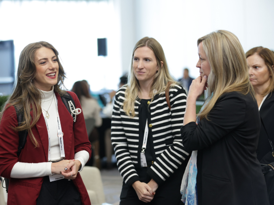 Three attendees talk and network during the Total Health women's breakfast.
