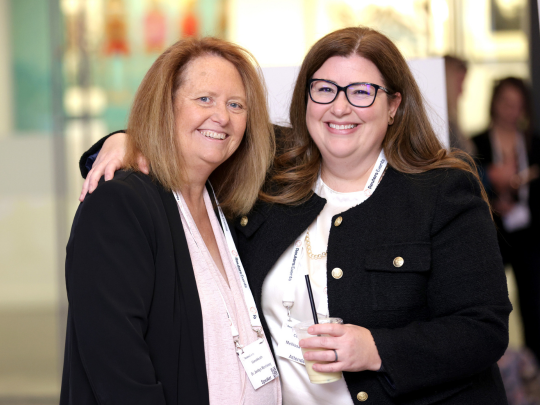 Two Total Health attendees pose together during a one-to-one networking meeting.