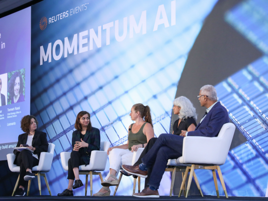 Five speakers participating in a Momentum AI panel discussion on stage.