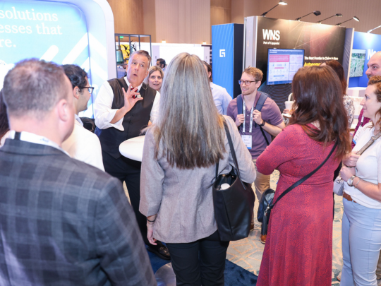Attendees gather around an exhibitor stand during a networking pit stop at Connected Claims USA.